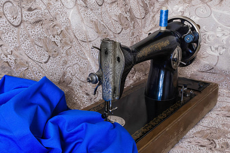 静物与古董缝纫机和亮蓝色织物图片