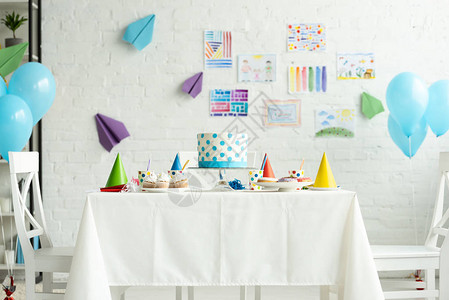 节日蛋糕和在餐桌上的派对帽在会议室装饰为生图片