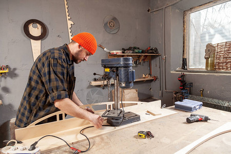 关闭在工作服雕刻木头的木匠在钻子手工作DIY灵感改进工作修理店头盔细木工创业理念工业教育图片