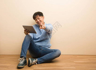 年轻人坐在平板上欢笑的坐着微图片