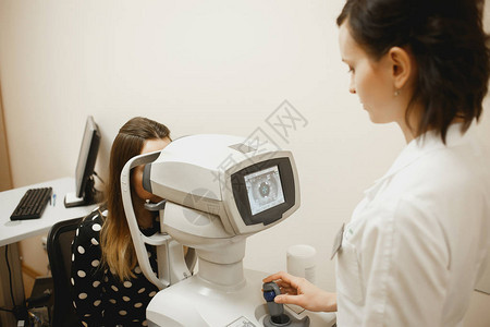 具有吸引力的女医生眼科医生正在检查现代诊所病人的视力图片