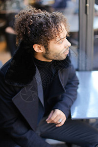 穿黑大衣的卷发非裔美国人年轻男概图片