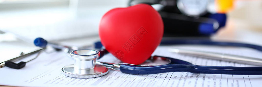 位于医生办公室工作台医疗申请表上的静脉透视镜头和红心形玩具心血管治疗师心脏生理体格检查心律失常和紧急复背景图片