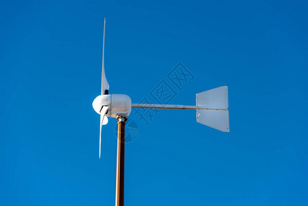 在清蓝的天空上关闭小型风力涡轮机可图片