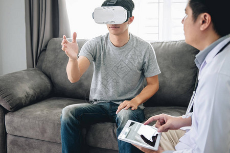 年轻的亚洲男病人使用虚拟现实眼镜看技术来检查身体病人图片