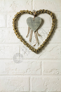 挂在旧白砖墙上的装饰木心图片
