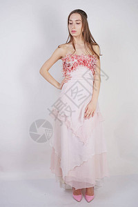 一个迷人的年轻白人女孩穿着粉色长舞会礼服图片