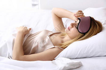 躺在床上戴着睡眠面具的女人图片