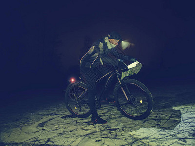 骑自行车的人在夜雪中迷失了道路背景图片