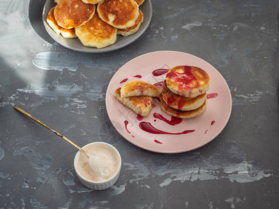 陶瓷板上自制的芝士蛋糕白冰淇淋碗加轮班和甜点勺子在灰色图片