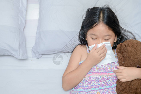 亚洲女孩用组织抽鼻子图片素材