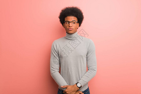 粉红色墙壁上的年轻非洲美国人图片