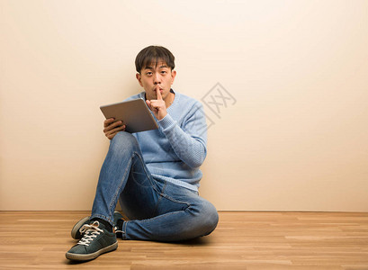年轻人坐着用平板电脑保守秘密或要求沉默图片