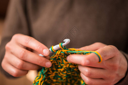 女人钩针手工钩针女手特写女手握住钩子复古地毯针织格子手工制作图片