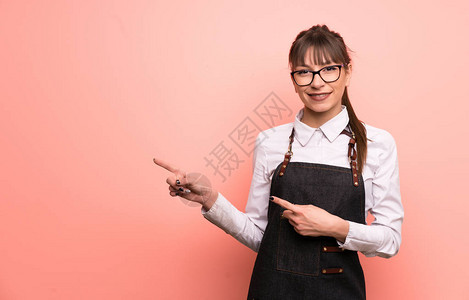 年青女服务员在粉红背景上图片