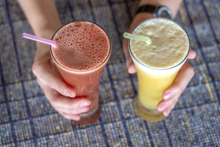 手握双杯菠萝和西瓜新鲜果汁闭合健康生活方式图片