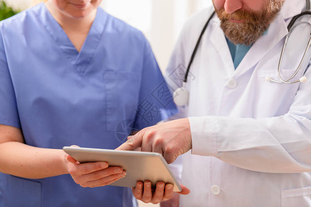 医生和护士在医院的平板电脑上讨论病人的测试或X射线图像医疗图片