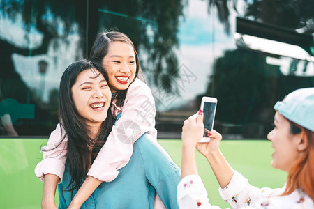 千禧一代亚洲女孩在户外使用手机图片