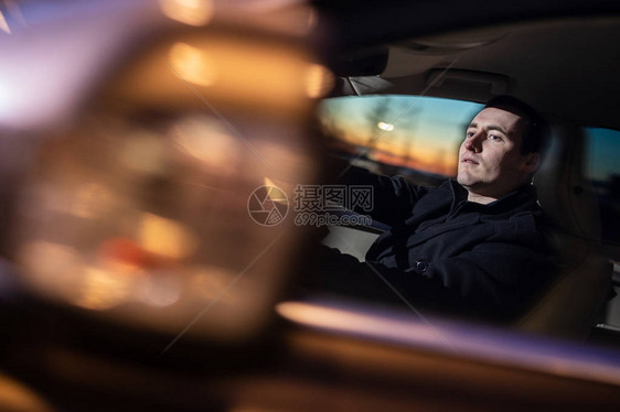 夜间驾驶汽车的英俊年轻男子图片