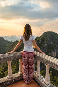 年轻女旅行者站在阳台的顶端图片