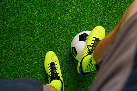 足球鞋和足球在绿草地上特写图片