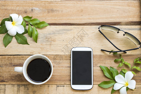 手机热咖啡太阳玻璃和白花茉莉frangipani安排在背景图片