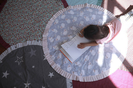 小女孩躺在圆垫上在相册里画顶视图图片