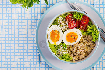 新鲜沙拉早餐碗配燕麦片西红柿生菜微绿蔬菜和煮鸡蛋健康食品素食碗图片