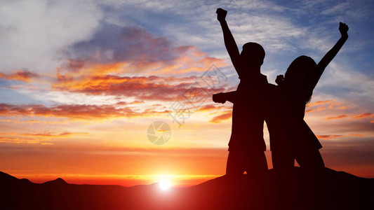 一对夫妇庆祝成功与日落时多彩的天空决战的休图片