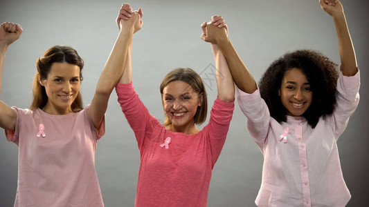 用粉色丝带向妇女微笑举起手来与图片