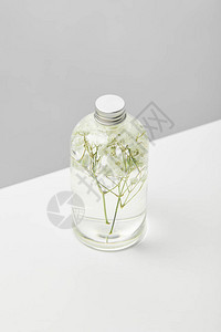 以透明瓶装的有机美容有机产品白桌上有草背景图片
