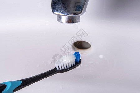 牙刷在流水下的水槽中清洗图片