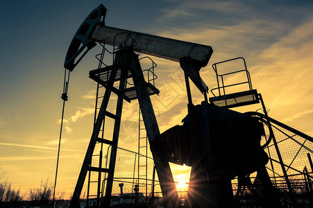 油田上的油泵千斤顶和井口采矿和石油工业发电概念石油和天图片