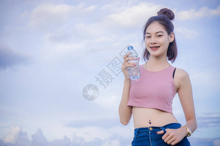 女孩的饮用水在瓶子里喝干图片