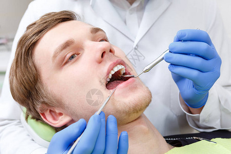 在牙医办公室的牙医处检查牙齿时图片