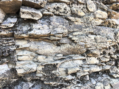石墙的纹理是岩石中古老石头砖的尖锐裂开的圆锥形粗糙天图片
