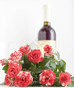 白色背景上的红色斑驳玫瑰背景为酒瓶图片