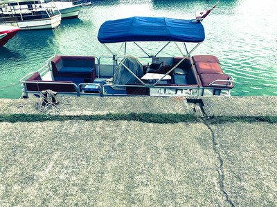 一艘小船有伸展的帆布屋顶站在海港上水图片