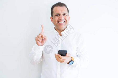 中年男子在白墙上使用智能手机的中年男子惊讶地看到一个想法或问题与快乐图片
