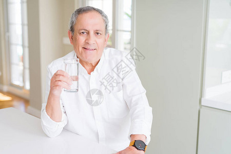 在家里喝杯清水的英俊高帅老人在聪明的面孔上自信地表图片