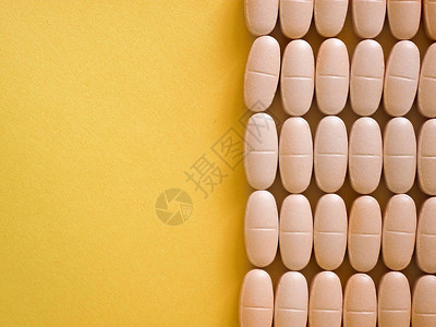 药房片背景复制空间模型与宏特写组药片黄色和粉红色的胶囊垂直右排线医疗保健治疗或维生图片