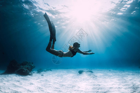 女人在带鳍的沙滩上自由潜水在海洋中自由潜水图片