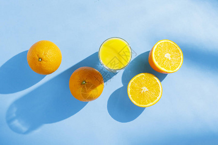 蓝色背景的橙汁和橙子一杯图片