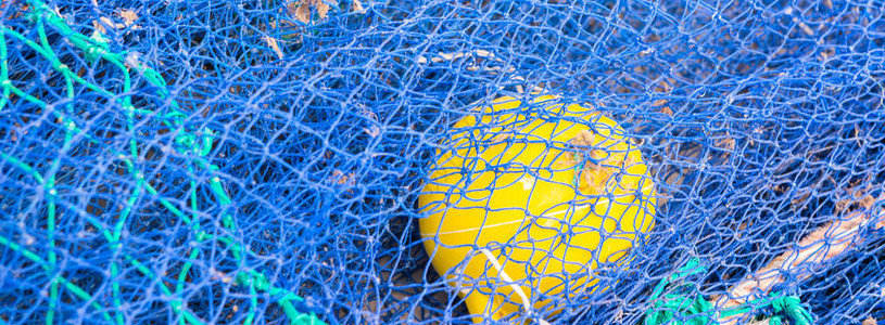 渔网和捕鱼线位于港口渔业的混凝土上的渔船图片
