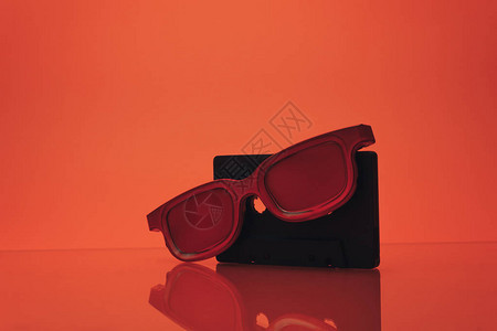 黑色经典磁带和玻璃桌上的红色眼镜美丽的珊瑚橙色图片