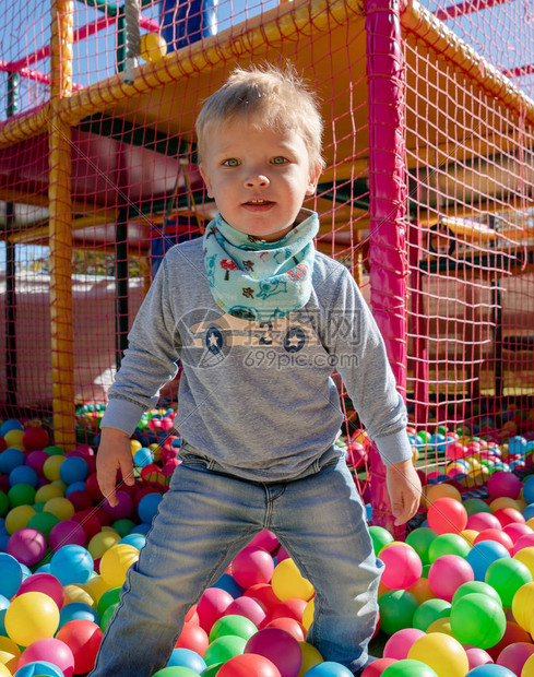 快乐的小男孩在彩色儿童游戏球场玩耍幸福的杂技游戏概念高图片