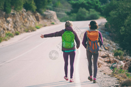 两个朋友停下车搭便车妇女在山路上赶车背着包的女孩在山路图片