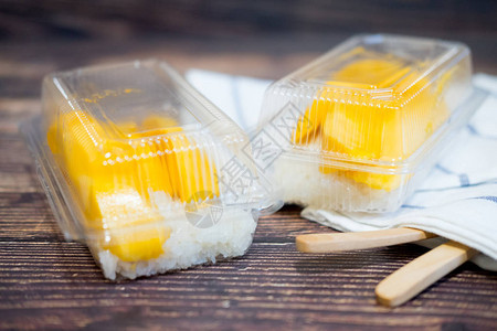 用透明塑料盒装芒果的糯米椰奶是泰国流行的传统甜点图片