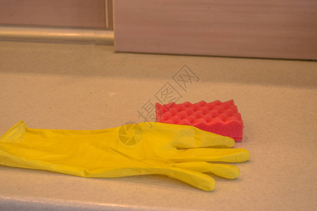 厨房橡胶手套和海绵中的清洁工具放在桌子的脏表面上图片