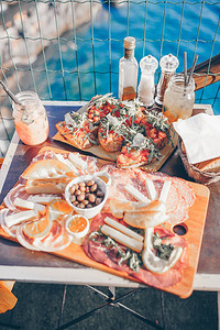 新鲜的粗食奶酪和肉类在户外咖啡厅的餐桌上图片